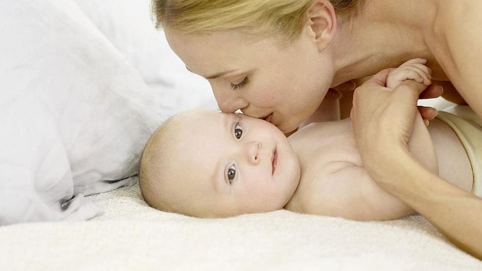 woman kissing baby